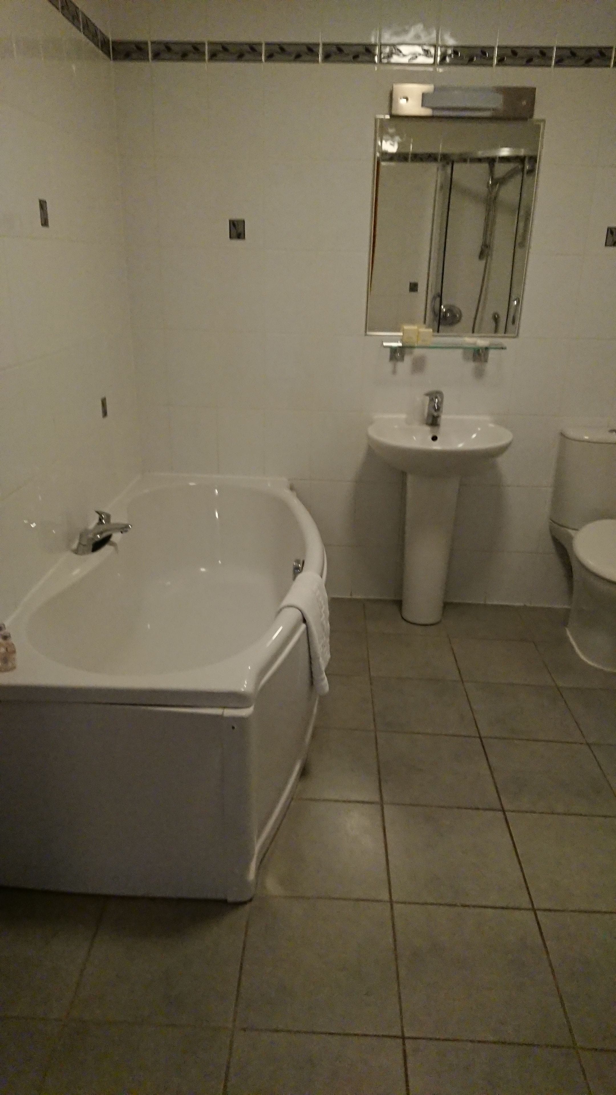 Un baño con bañera, lavabo e inodoro.