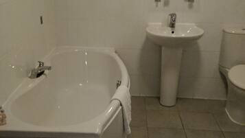 A bathroom with a bathtub, sink, and toilet.