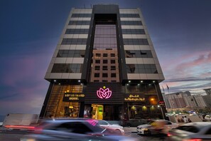 A hotel with a modern facade, large windows, and a prominent logo. - Lotus Grand Hotel Dubai (Dubai)