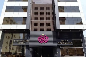 A modern building with a prominent logo and signage for the Lotus Grand Hotel.