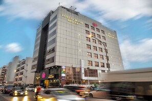 A multi-story hotel with a prominent sign for the Lotus Grand Hotel. - Lotus Grand Hotel Dubai (Dubai)