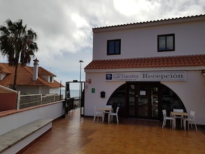 A reception area with a tiled floor, white walls, and a sign that reads 'Las Fuentes Recepción'. - Las Fuentes (Arona)
