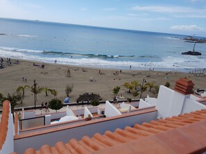 A beach with people, umbrellas, and a lifeguard tower. - Las Fuentes (Arona)