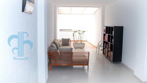 Un salon moderne avec un canapé, une table basse et une bibliothèque.