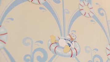 Primer plano de una tela con un diseño de remolinos y un pequeño personaje de caricatura.
