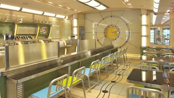 A modern restaurant with a long counter, seating area, and a decorative wall with a circular design.