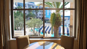 A hotel room with a large window, a round table, and two chairs. - Disney Ambassador Hotel (Urayasu)