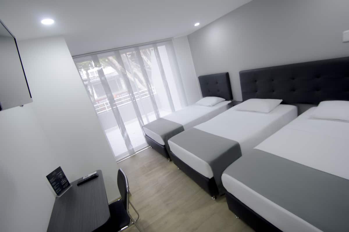 Una habitación de hotel con dos camas individuales, un escritorio y una silla.