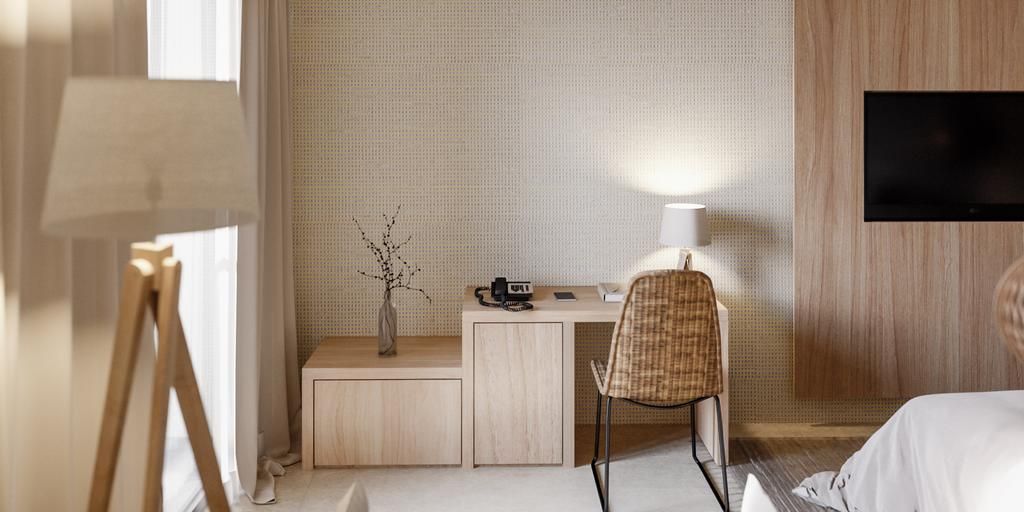 A hotel room with a desk, chair, lamp, TV, and a bed.