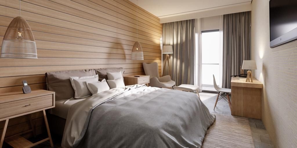 Quarto de hotel moderno com uma cama grande, mesas de cabeceira, uma escrivaninha e uma cadeira.