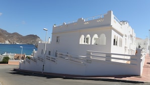A white building with a balcony and a sign that reads "Calle Granville." - Aparthotel Vistamar (Nijar)