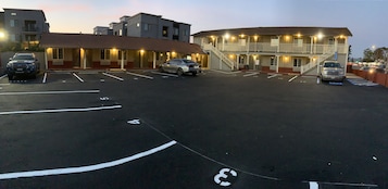 Un hotel con estacionamiento, varios pisos y una escalera que lleva a los niveles superiores.