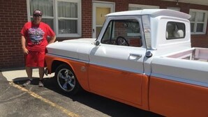 A vintage pickup truck parked in front of a building with a brick facade. - Sharon Motel (Wells)