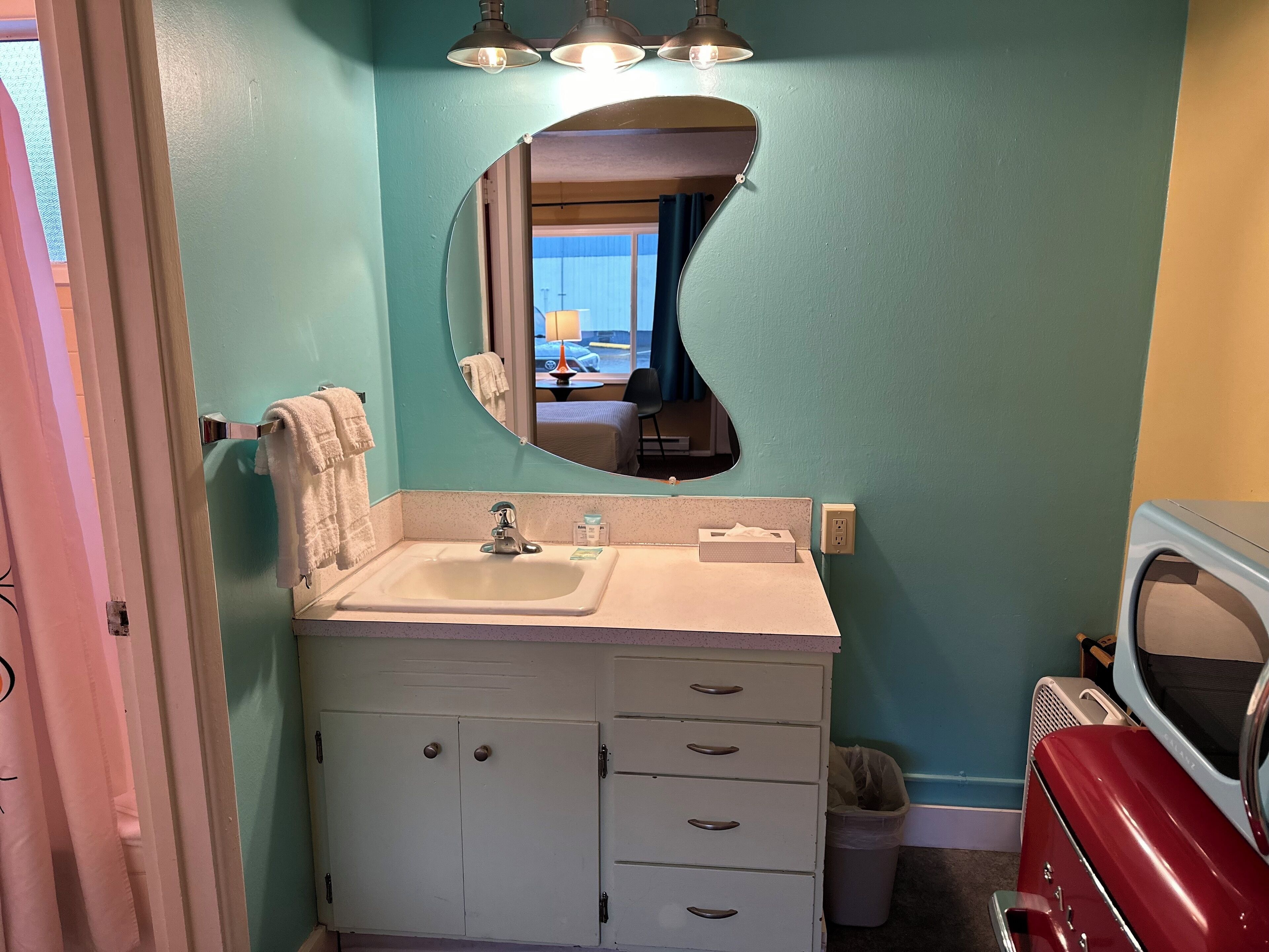 A bathroom with a sink, mirror, and cabinets.