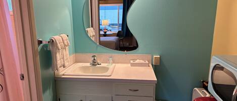 A bathroom with a sink, mirror, and cabinets.