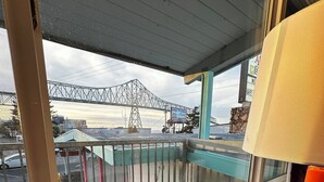 A balcony with a view of a bridge and a building in the background.