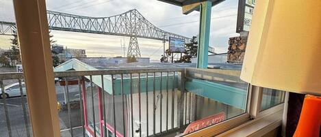 A balcony with a view of a bridge and a building in the background.