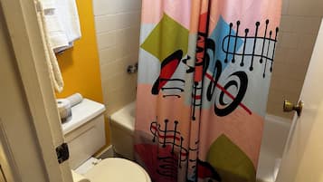 A bathroom with a toilet, sink, and shower curtain.