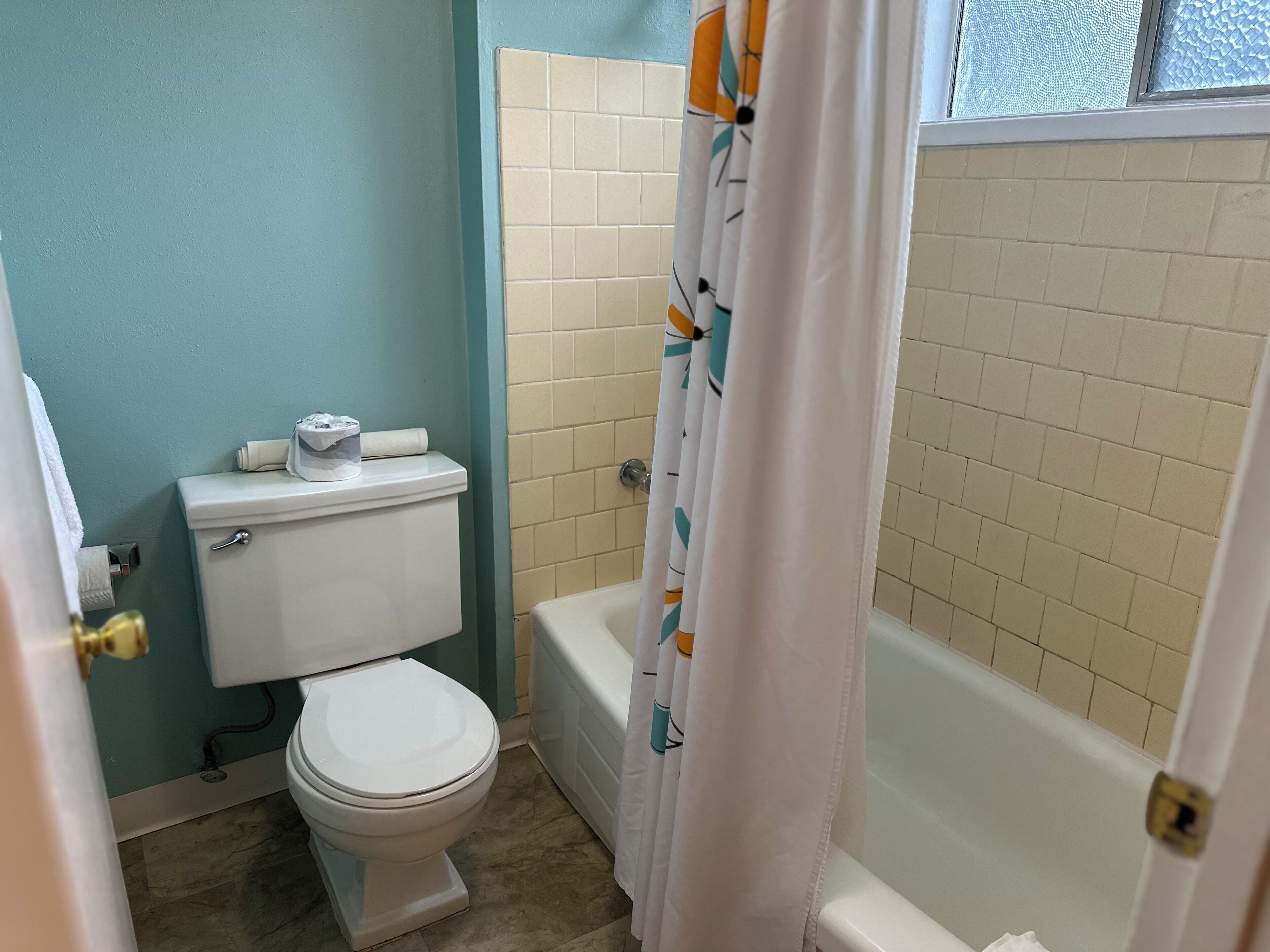 Un baño con inodoro, bañera y cortina de ducha.