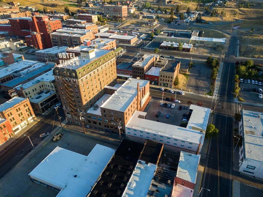 An aerial view of a downtown area with a prominent building labeled "HOTEL" and a parking lot.