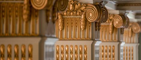 Ornate golden columns with intricate designs and a classical architectural style.