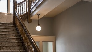 Eine imposante Treppe mit hölzernem Geländer und einem Marmorpodest.