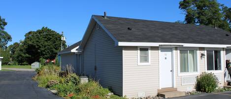A single-story house with a front porch, a garage, and a small garden area.