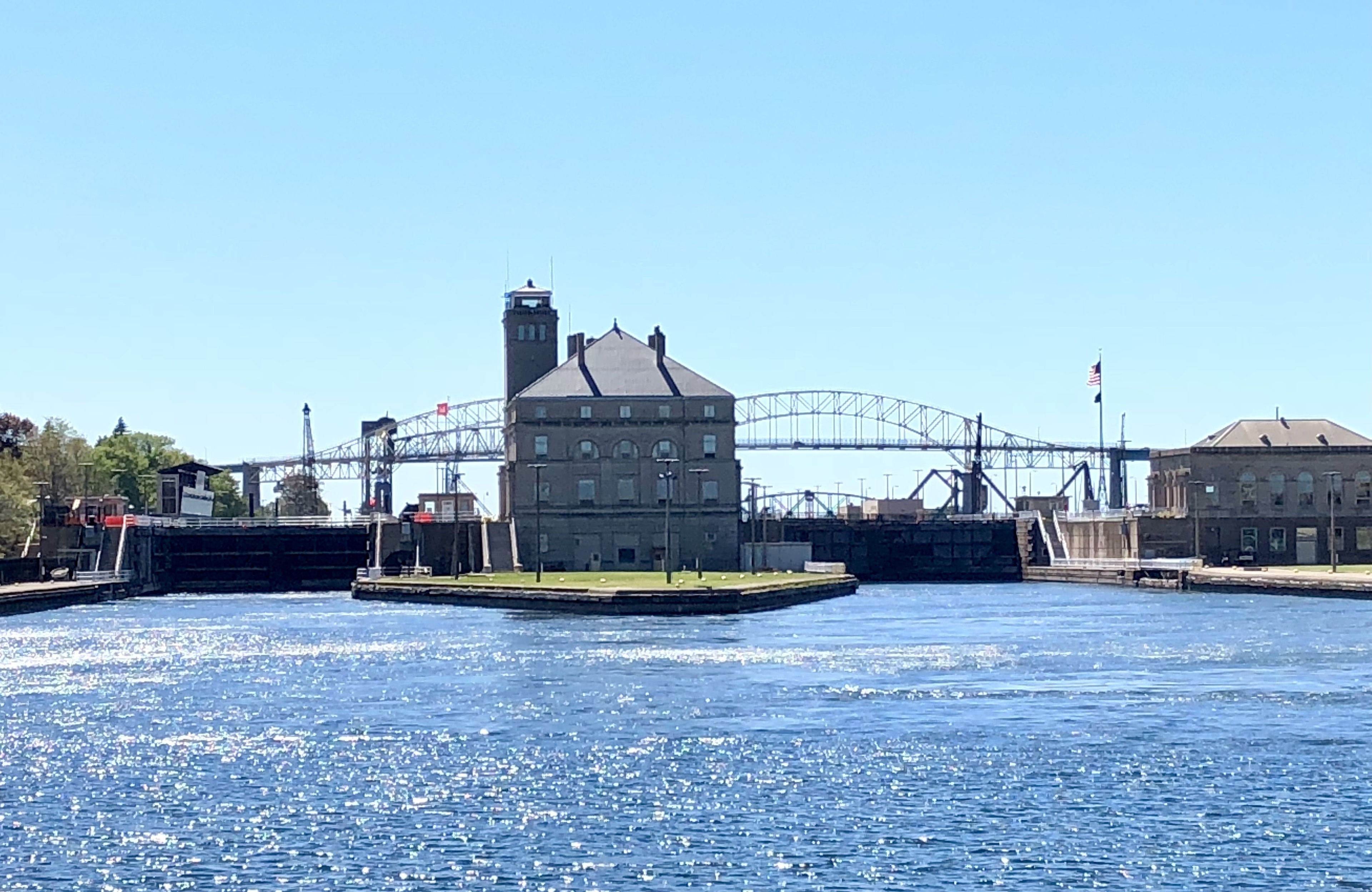 Un bâtiment situé au bord de l’eau, avec un pont en arrière-plan.
