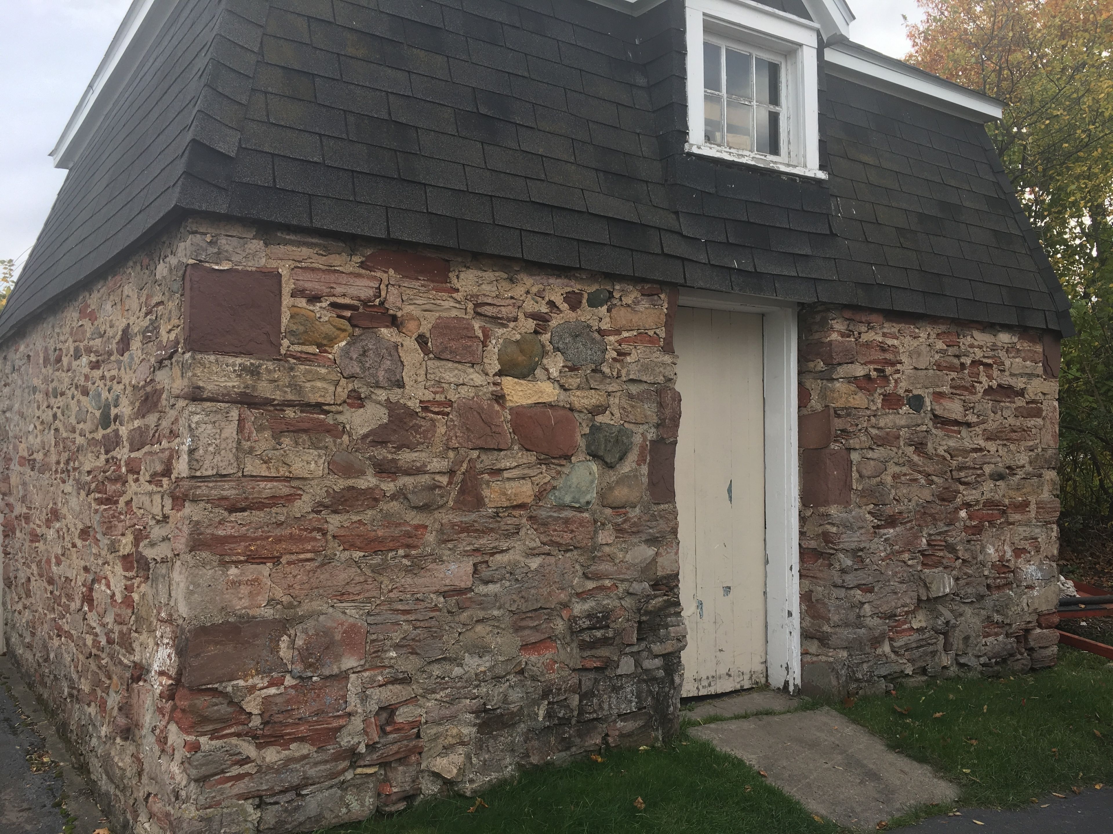 A stone building with a small door and a window.