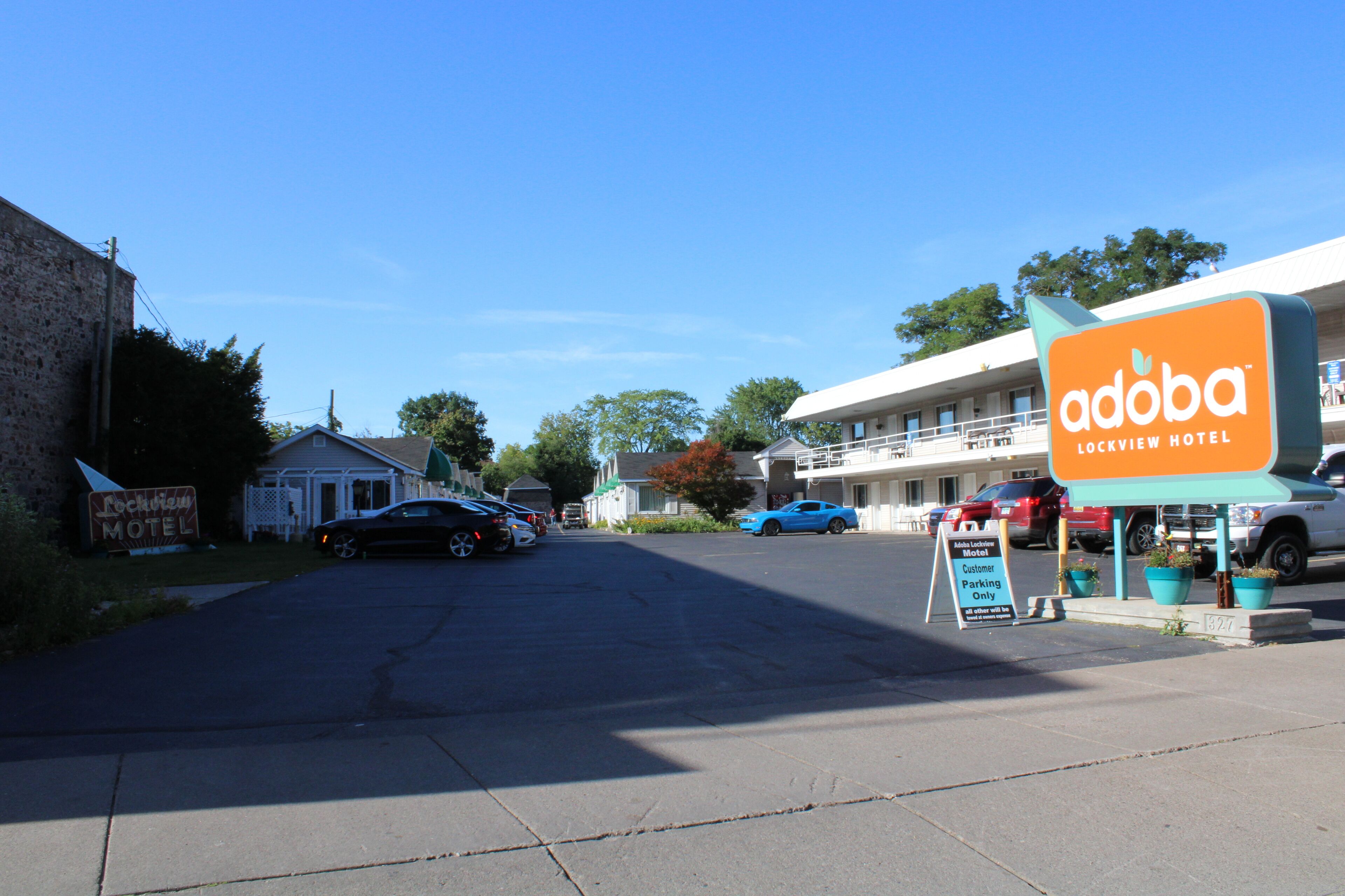 A motel with a sign for 'Adoba Lockview Hotel' and a parking sign indicating 'Customer Parking Only'.