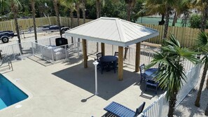 A covered patio area with a pool, seating, and a fenced enclosure.