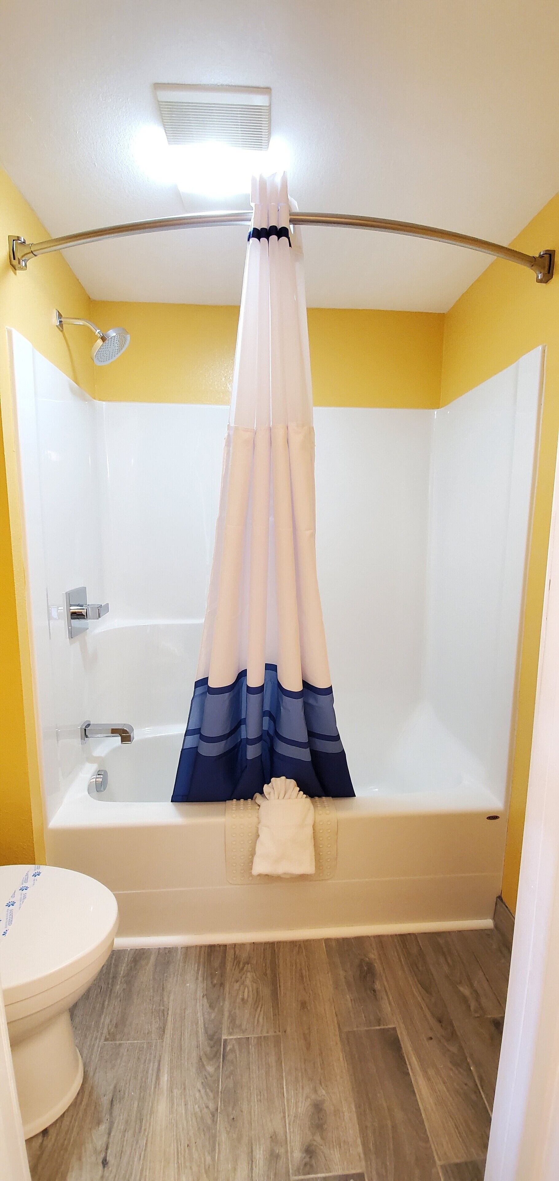 Un baño con bañera, ducha e inodoro.