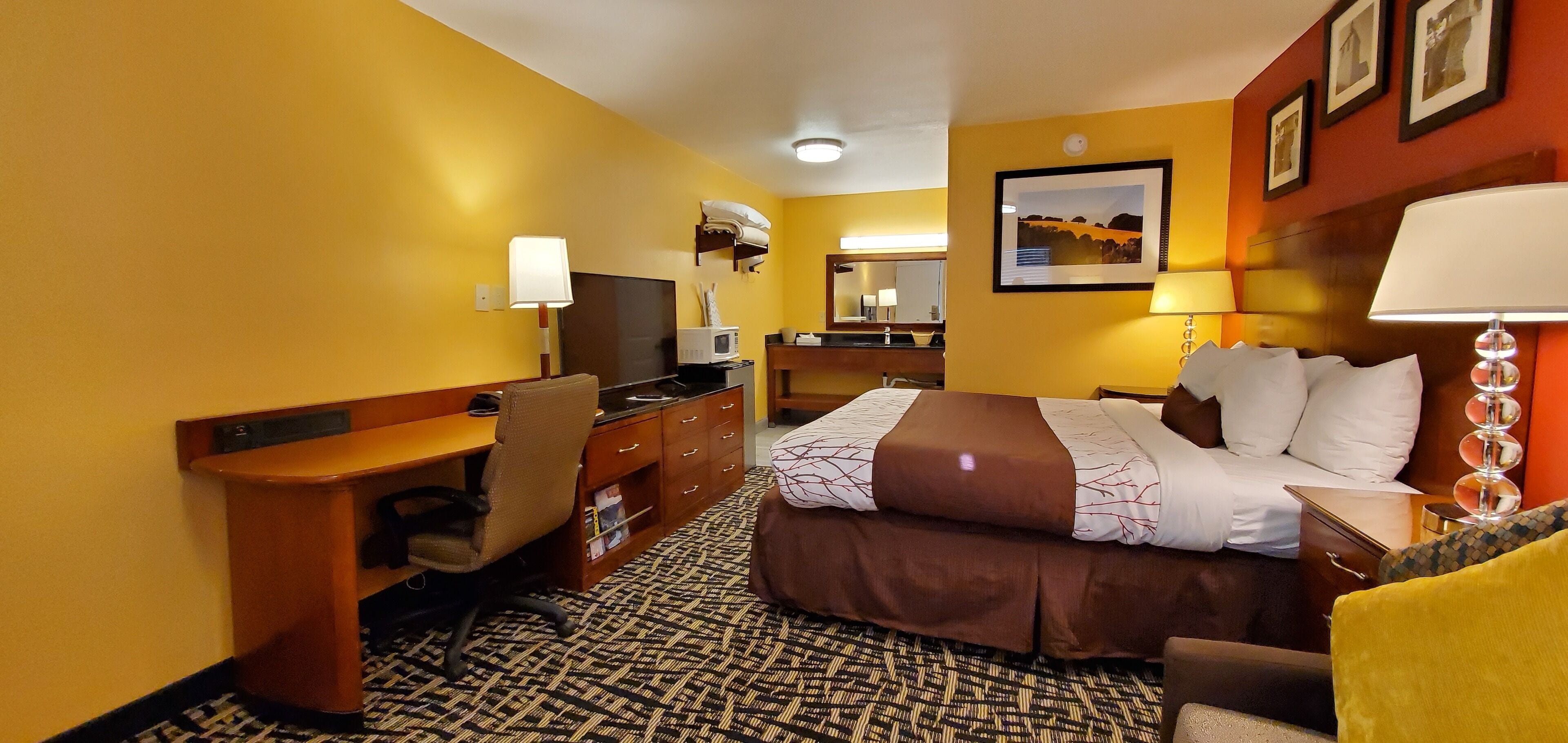 Une chambre d’hôtel équipée d’un lit, d’un bureau, d’une chaise et d’un téléviseur.