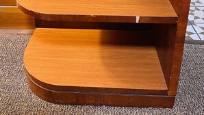 A wooden counter with a coffee maker and a donut shop blend coffee package.