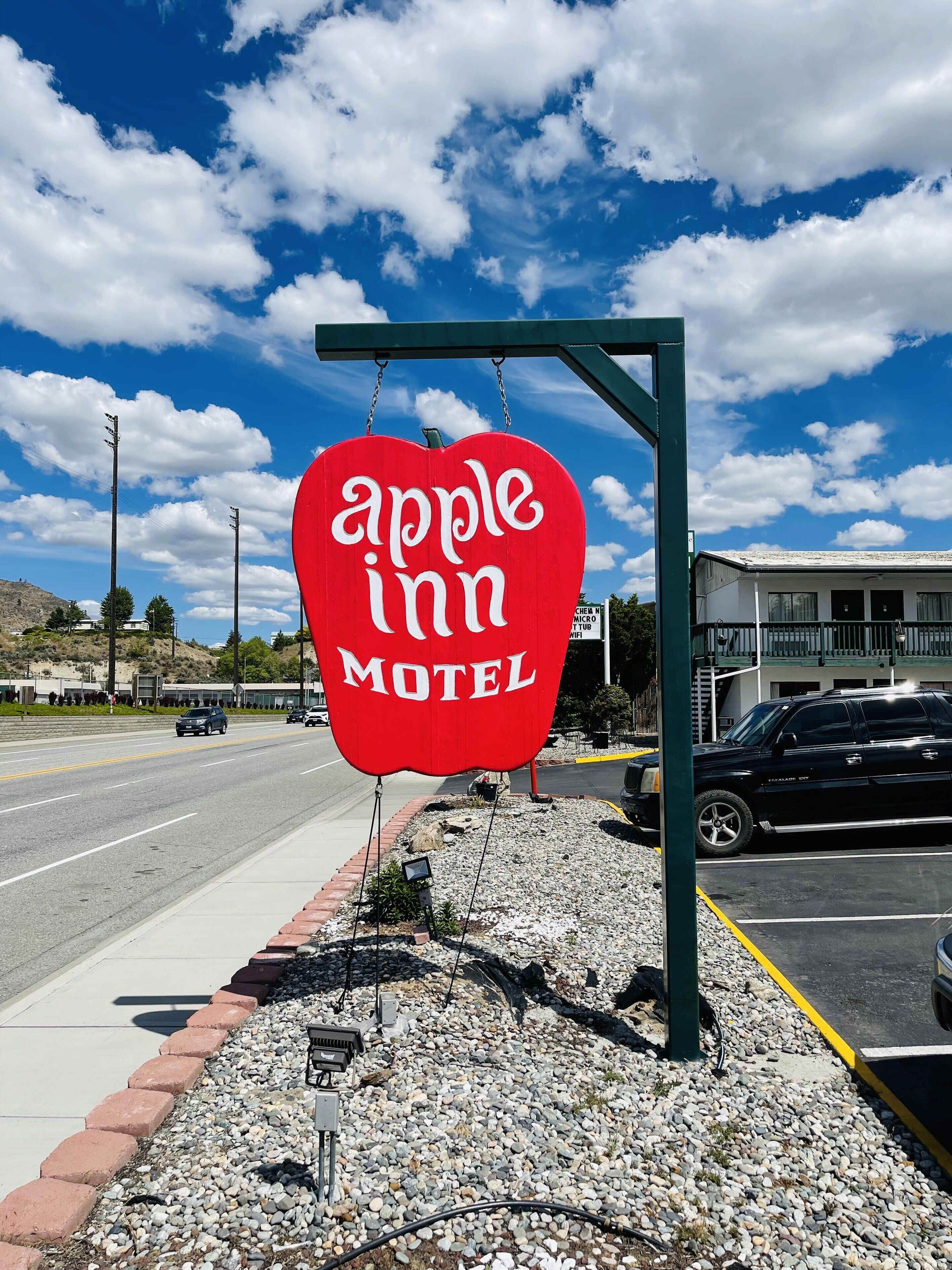 Segno a forma di cuore rosso per il Motel Apple Inn, con un cielo sereno sullo sfondo.