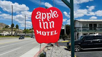 Segno a forma di cuore rosso per il Motel Apple Inn, con un cielo sereno sullo sfondo.
