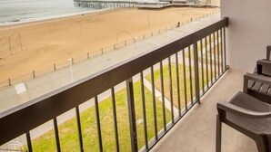 A balcony with a view of a beach and pier. - Breakers Resort Inn (Virginia Beach)