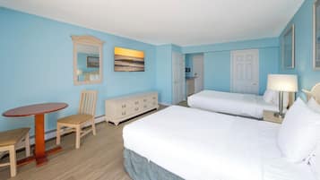 Habitación de hotel con una cama grande, una mesita, una silla, un tocador y un cuadro en la pared.