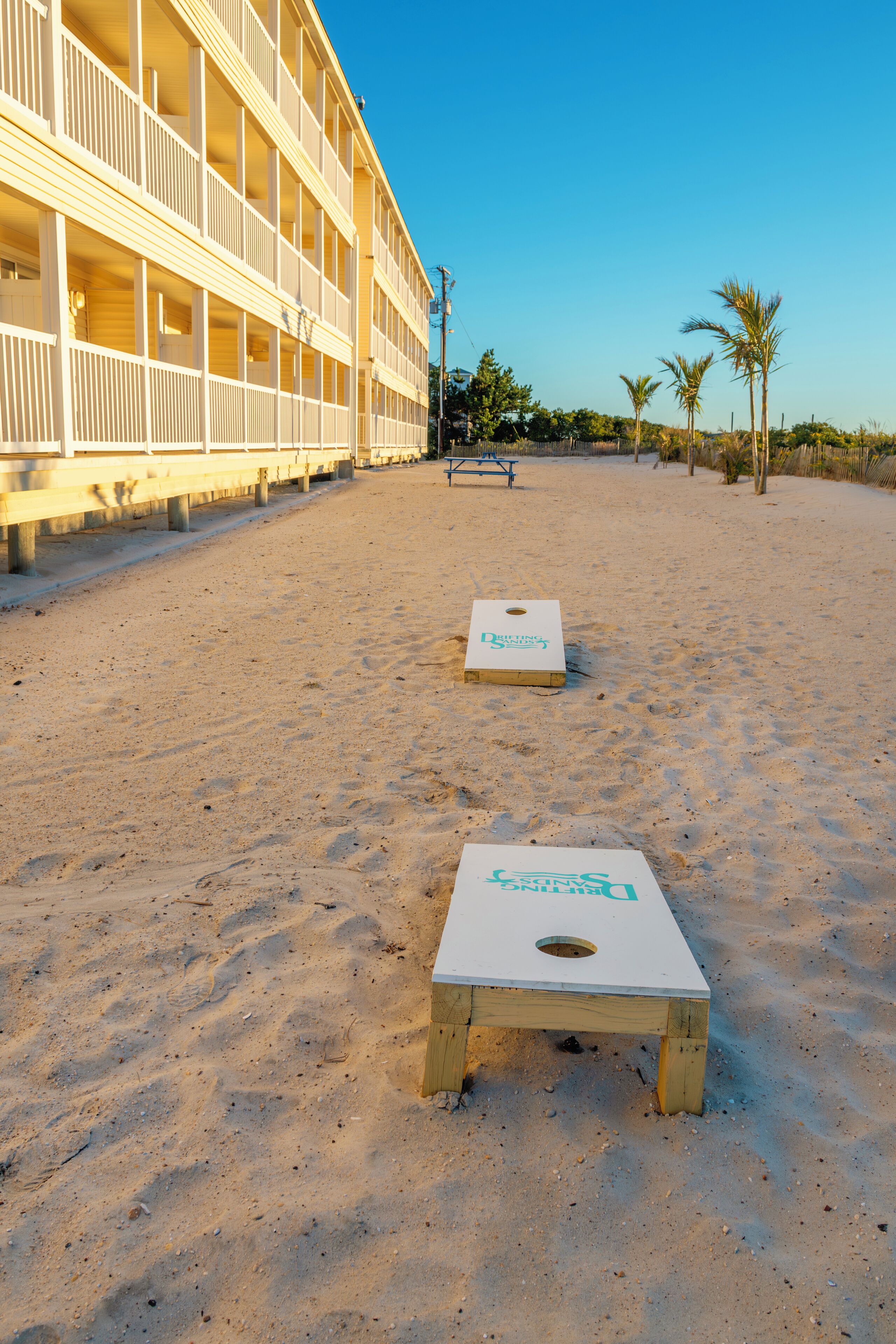 Et hotel ved stranden med poolområde og to shuffleboard-baner.