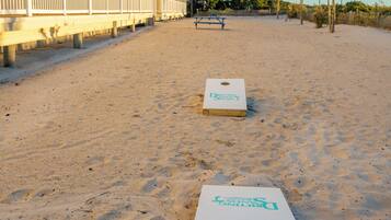Un hotel frente a la playa con zona de piscina y dos canchas de shuffleboard.