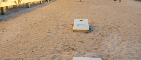 Et hotel ved stranden med poolområde og to shuffleboard-baner.