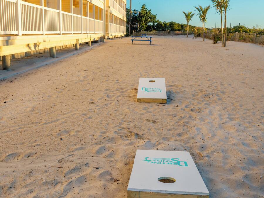 Un hotel frente a la playa con zona de piscina y dos canchas de shuffleboard.