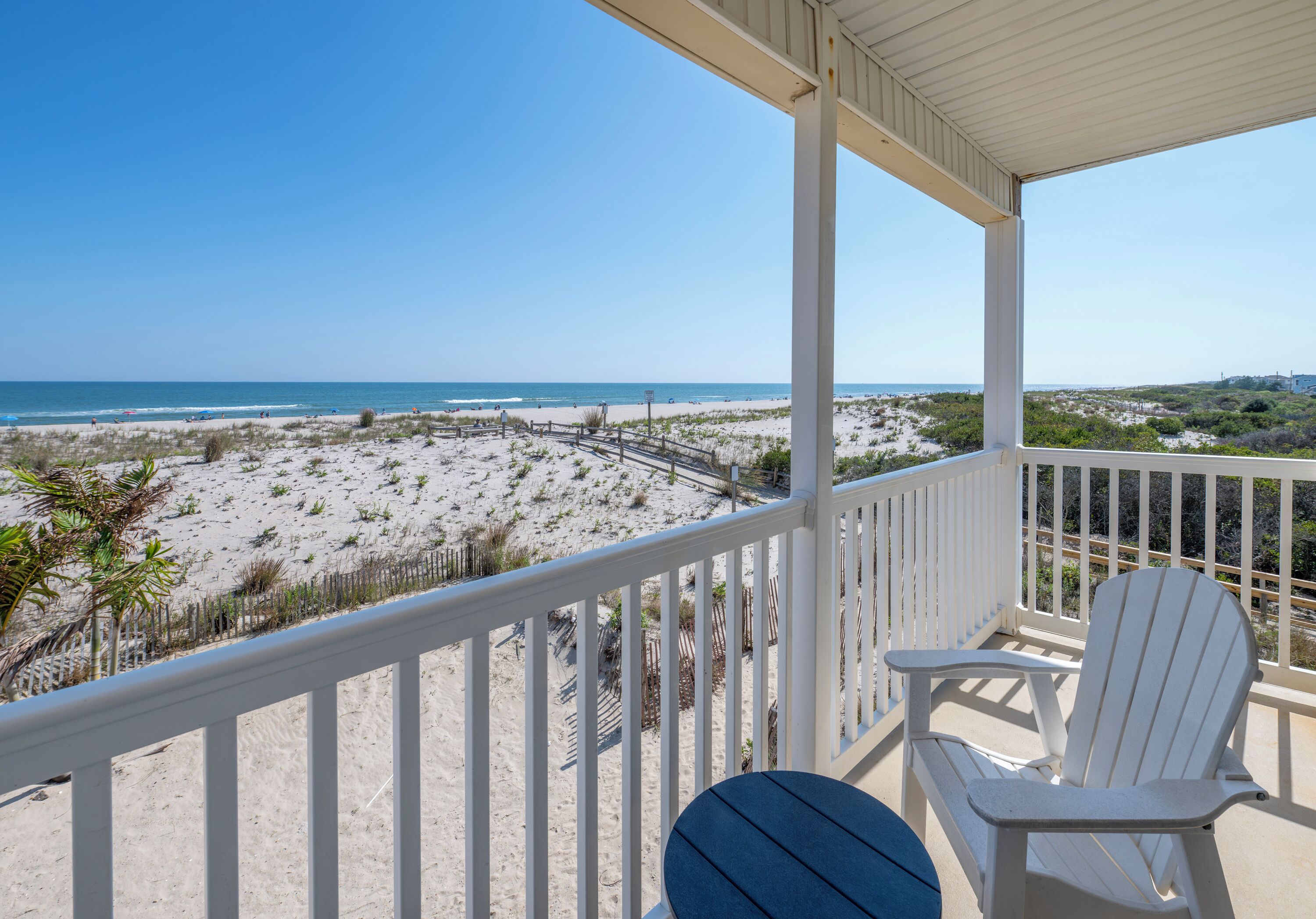 A balcony with a view of the beach and ocean.