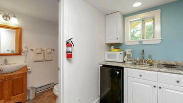A kitchen with white cabinets, a microwave, and a sink.