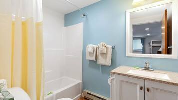 A bathroom with a bathtub, toilet, and sink.