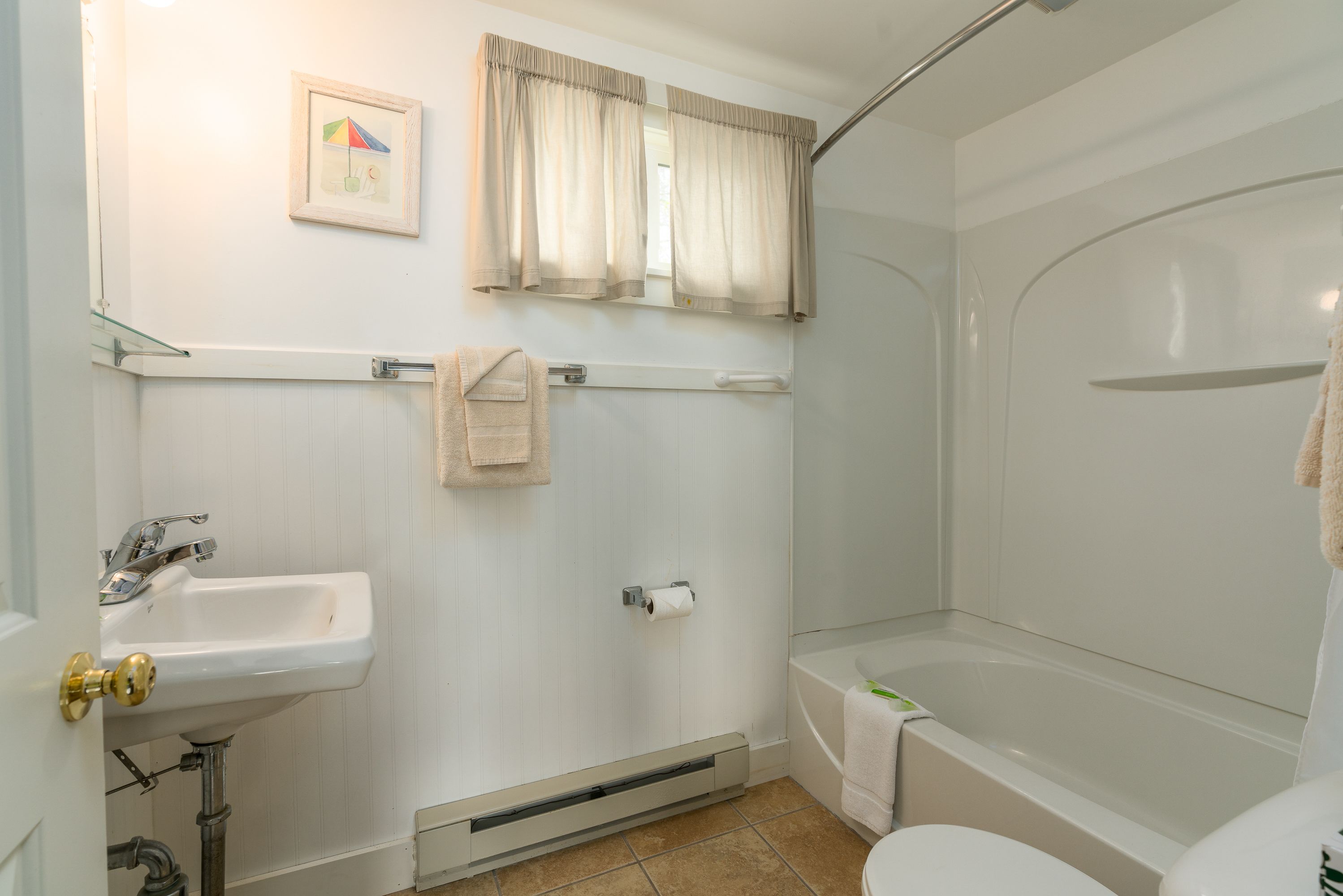 A bathroom with a sink, toilet, and bathtub.
