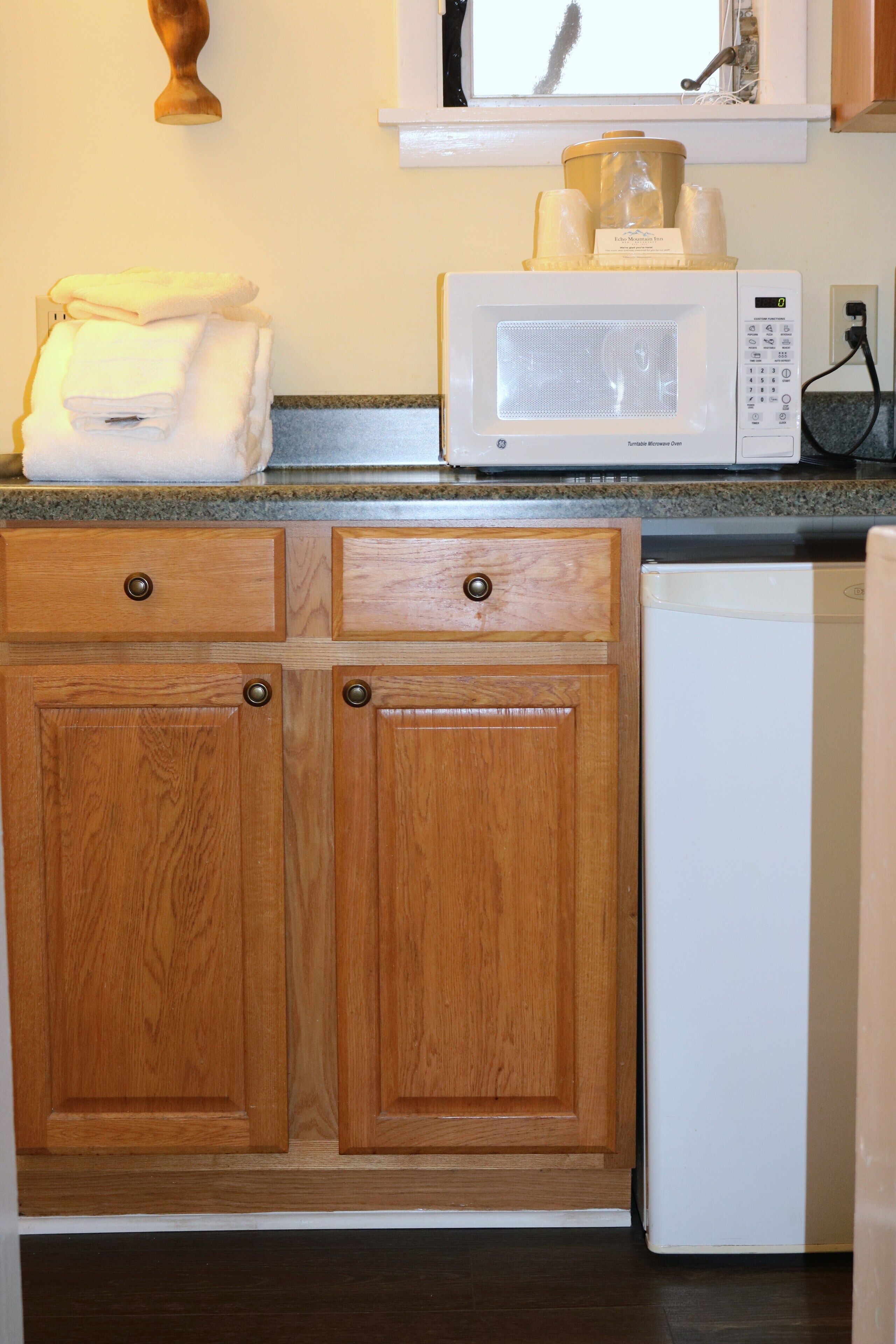 A kitchen with wooden cabinets, a microwave, and a dishwasher.