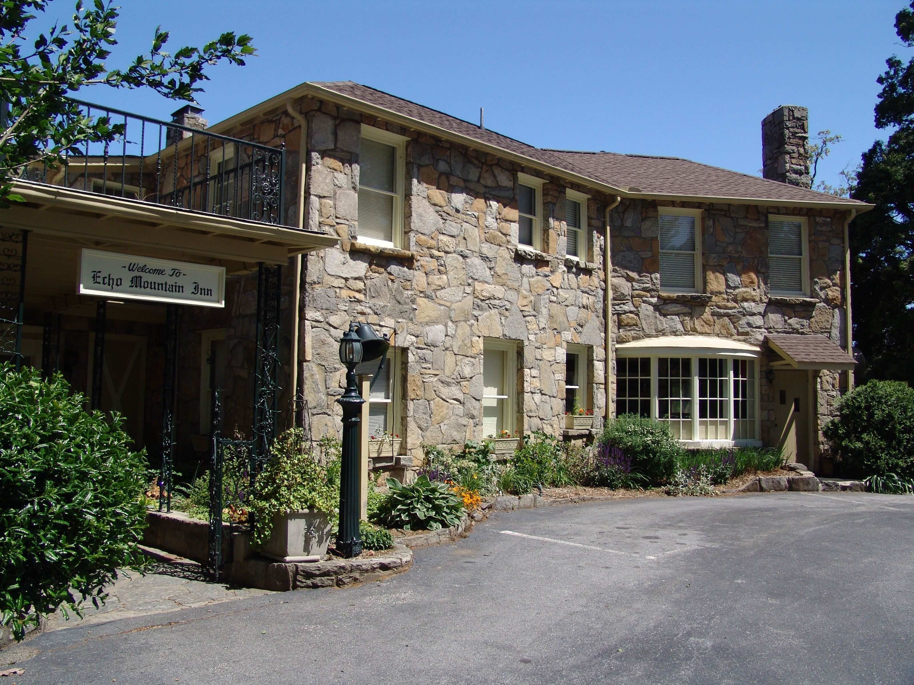 Ein Steinhaus mit Balkon und einem Schild, auf dem steht: "Welcome to Echo Mountain Inn".