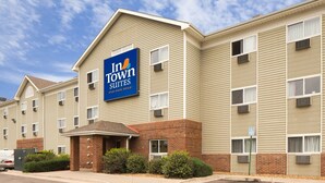 A multi-story hotel with a prominent 'Inn at Town Suites' sign, featuring a brick entrance and multiple windows. - InTown Suites Extended Stay Denver CO - Englewood (Englewood)