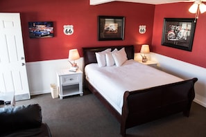 Een hotelkamer met een bed, nachtkastjes en decoraties aan de muur, waaronder Route 66 borden.